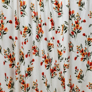 Ribbed Knit Stretch Fabric. 4 way stretch. Very Pretty Ivory with Orange and Green floral print. Fabric is sold by the 1/2 Yard .