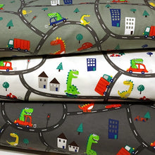 Load image into Gallery viewer, European Knit Fabric, Dinosaurs in the City in Trucks and Cars, 4-way stretch Cotton Spandex jersey knit, Sold by the 1/2 yard.
