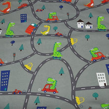 Load image into Gallery viewer, European Knit Fabric, Dinosaurs in the City in Trucks and Cars, 4-way stretch Cotton Spandex jersey knit, Sold by the 1/2 yard.
