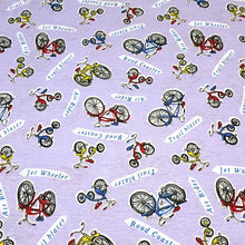 Load image into Gallery viewer, Cotton Jersey T-Shirt Knit, Bike Fabric with Bicycles and Tricycle on Lavendar Background. 2-way stretch. Sold by the 1/2 yard
